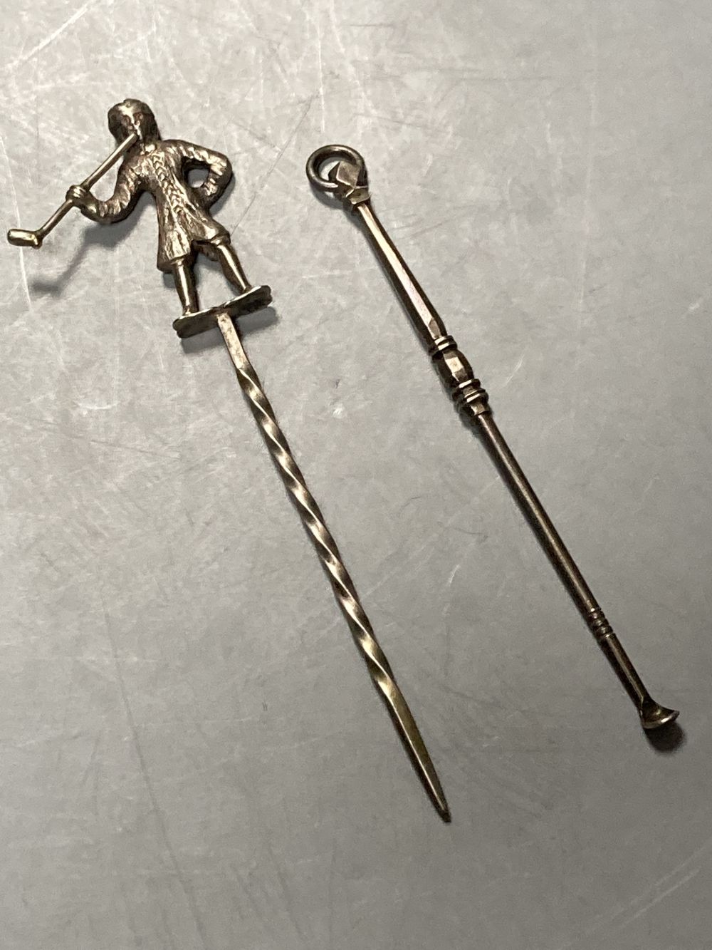 An 18th century white metal snuff spoon, with panelled, turned stem, 97mm and a white metal game skewer